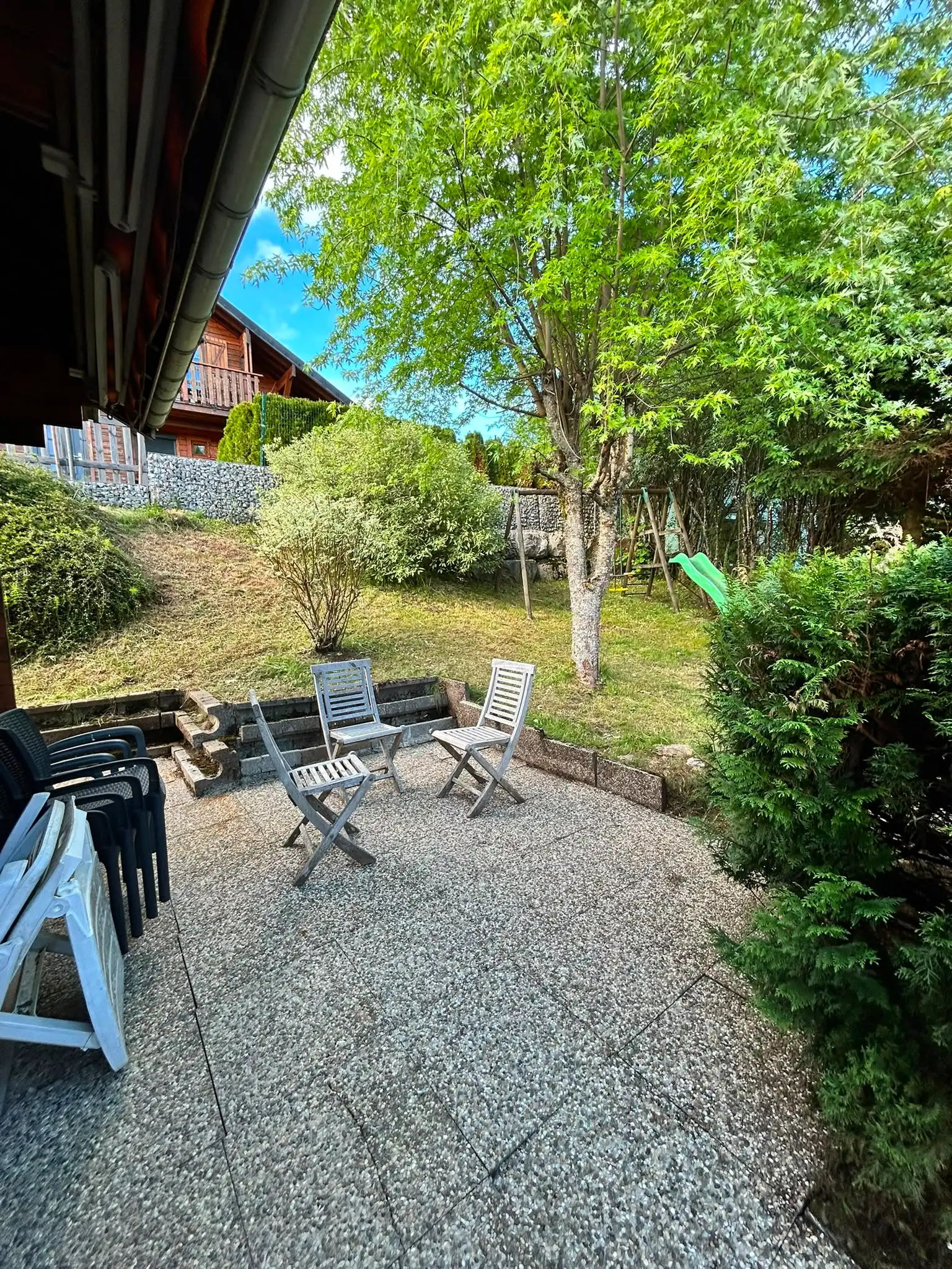 Terrasse en dalles gravillonnées après nettoyage, devant un chalet