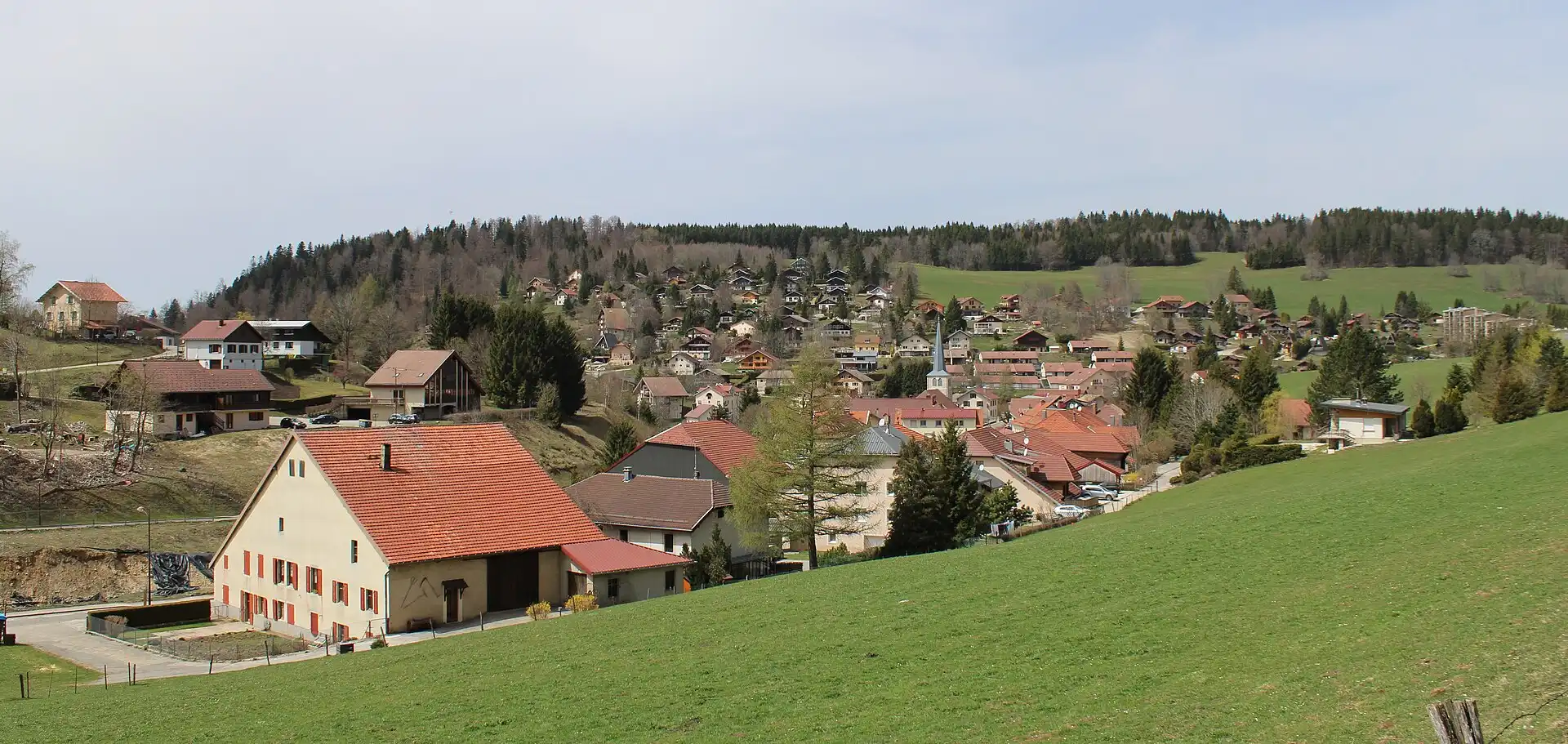 Le village des Hôpitaux-Neufs à flanc de colline, sous la forêt